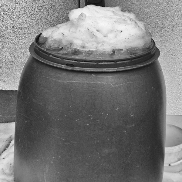 Regentonne mit Schnee